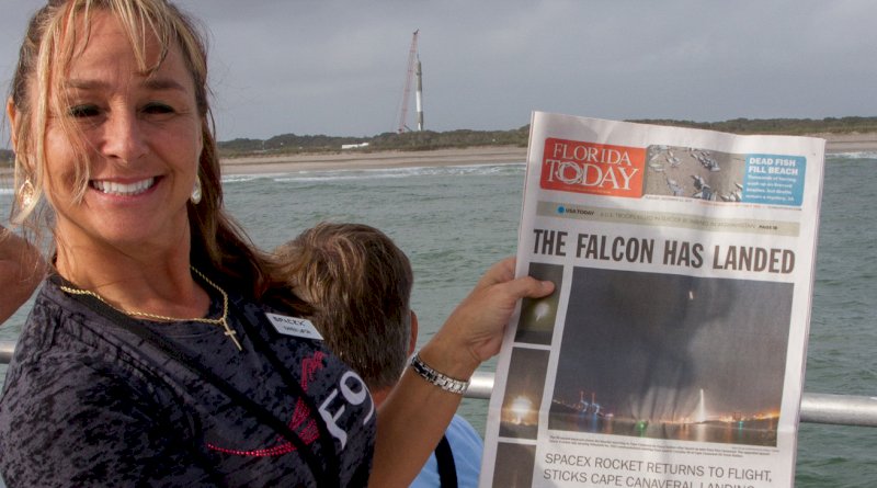Karen LaFon holds the Falcon has Landed headline in front of the Falcon 9 that landed in Florida. Photo: Bill Jelen