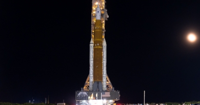 Backdropped by the moon and lit with powerful spotlights, the Artemis I / Space Launch System rocket traverses four miles to Launch Complex 39B at Kennedy Space Center.