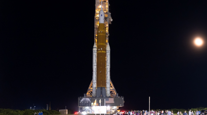 Backdropped by the moon and lit with powerful spotlights, the Artemis I / Space Launch System rocket traverses four miles to Launch Complex 39B at Kennedy Space Center.